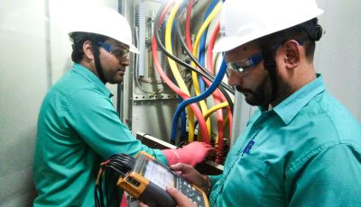 Power quality audit technicians checking electrical panel with analyzer for voltage fluctuations and power performance