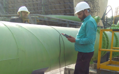 Engineers conducting water pipeline inspection using monitoring equipment for industrial water audit
