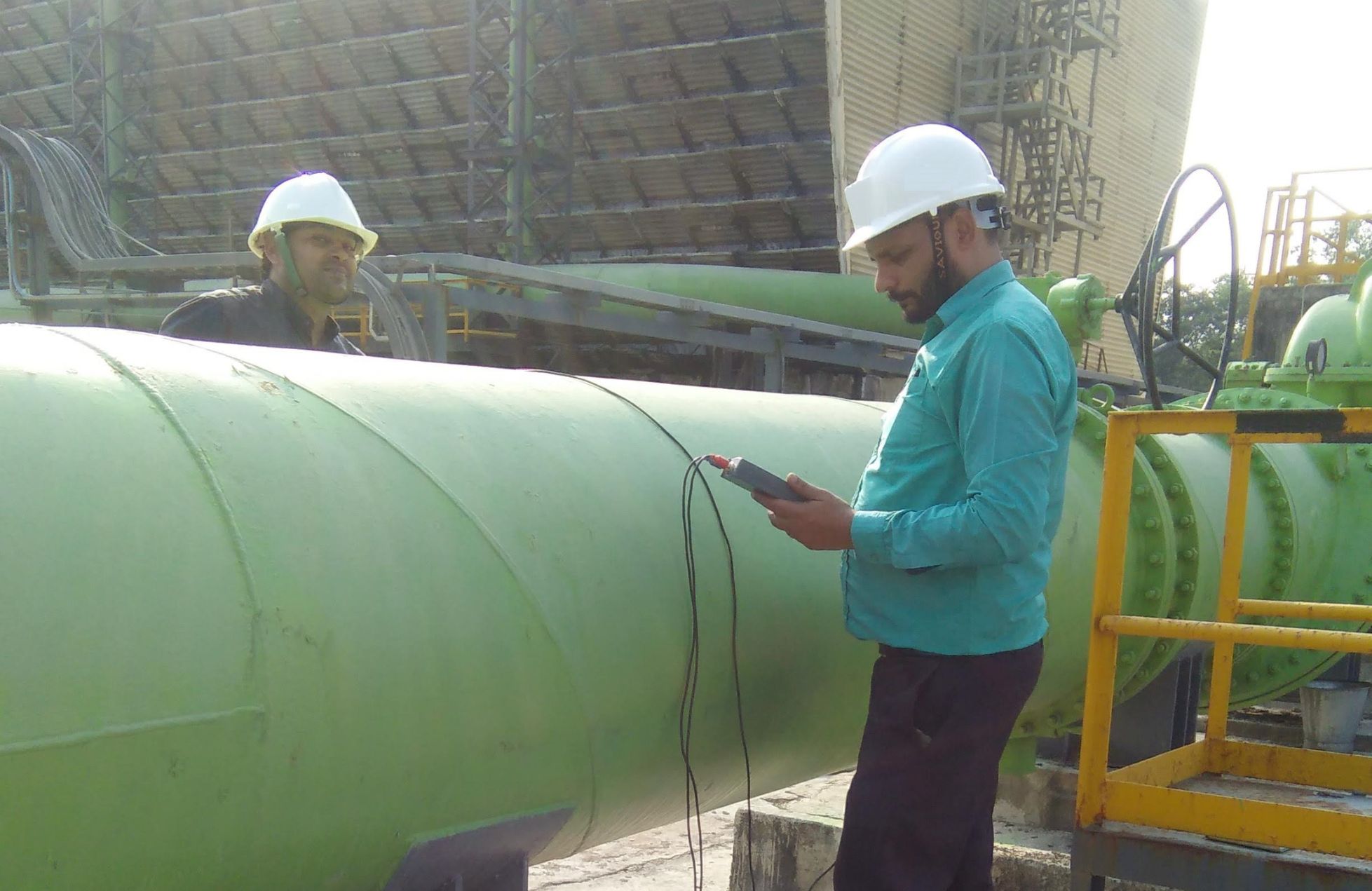 Engineers conducting water pipeline inspection using monitoring equipment for industrial water audit
